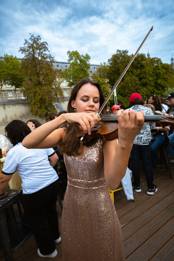 La violoniste en robe à sequins joue sur le pont